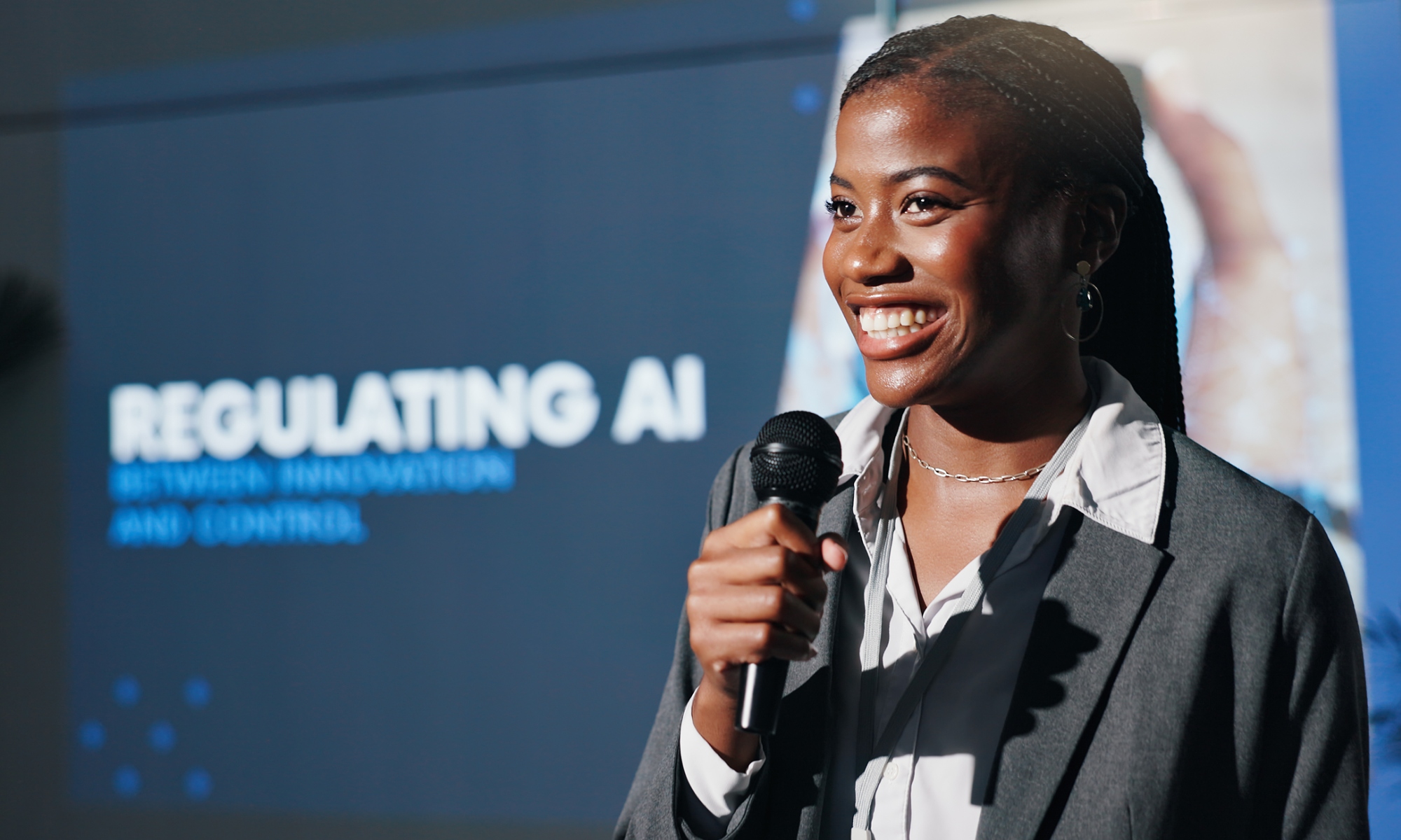 A woman holds a microphone as a speaker at an AI event
