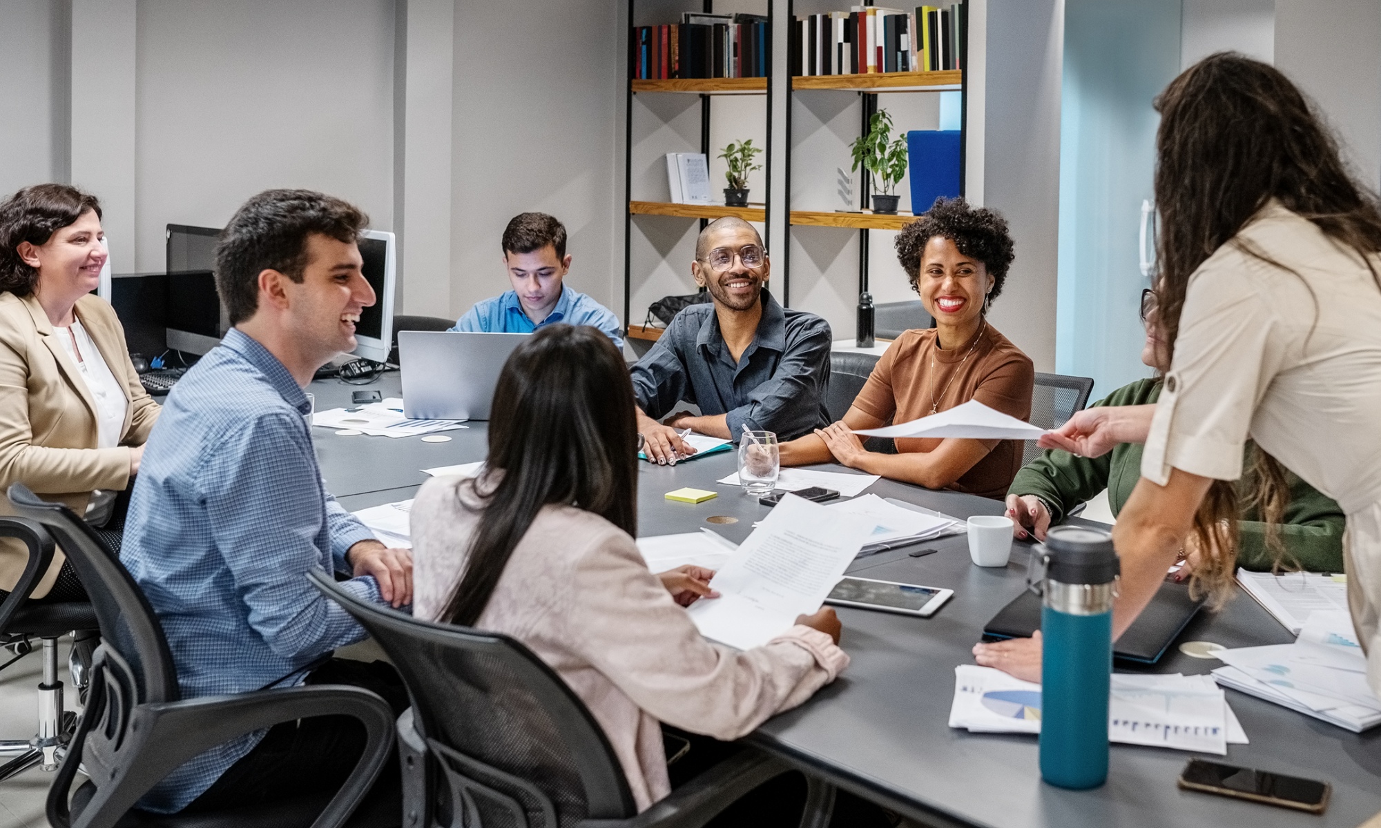 A group of business leaders sits at a table for a meeting