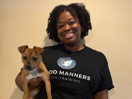 Asia Poe is holding a dog with a smiling face.