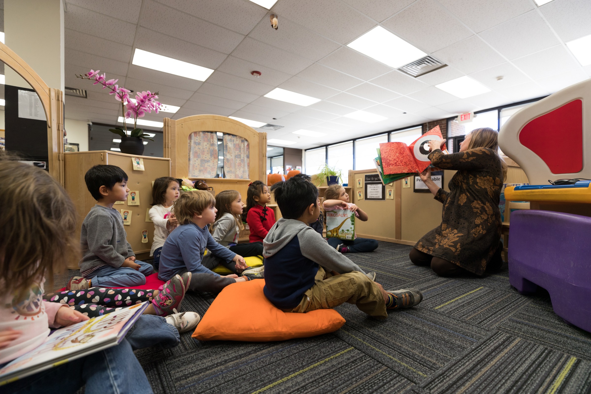 Children sit in a group while a teacher does a read aloud