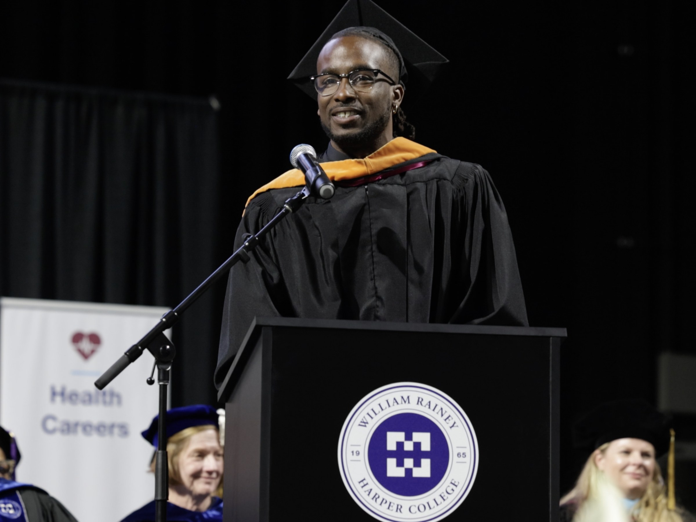 Isaac Jean-Paul speaks at podium