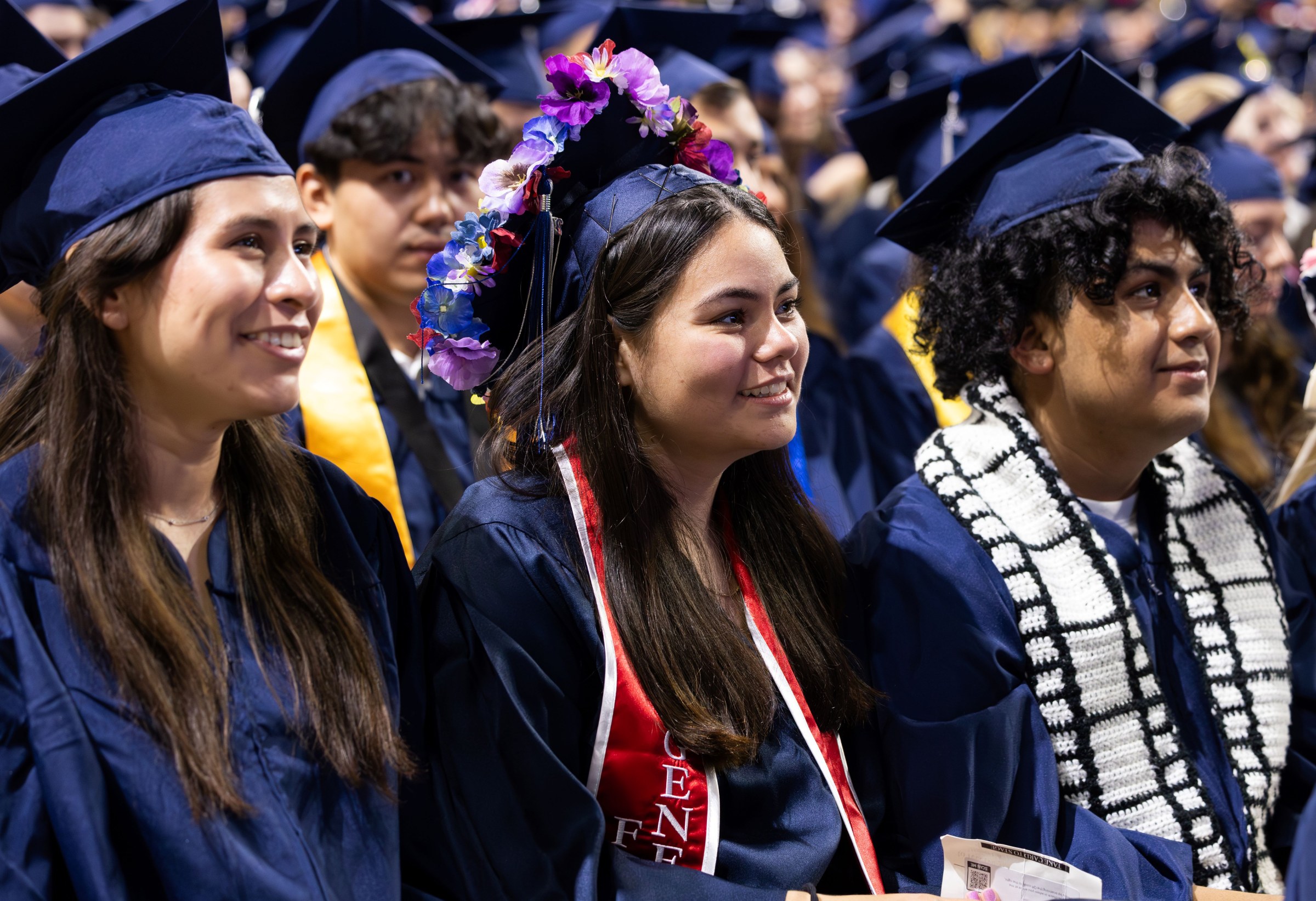 Three Harper graduates listen to speaker