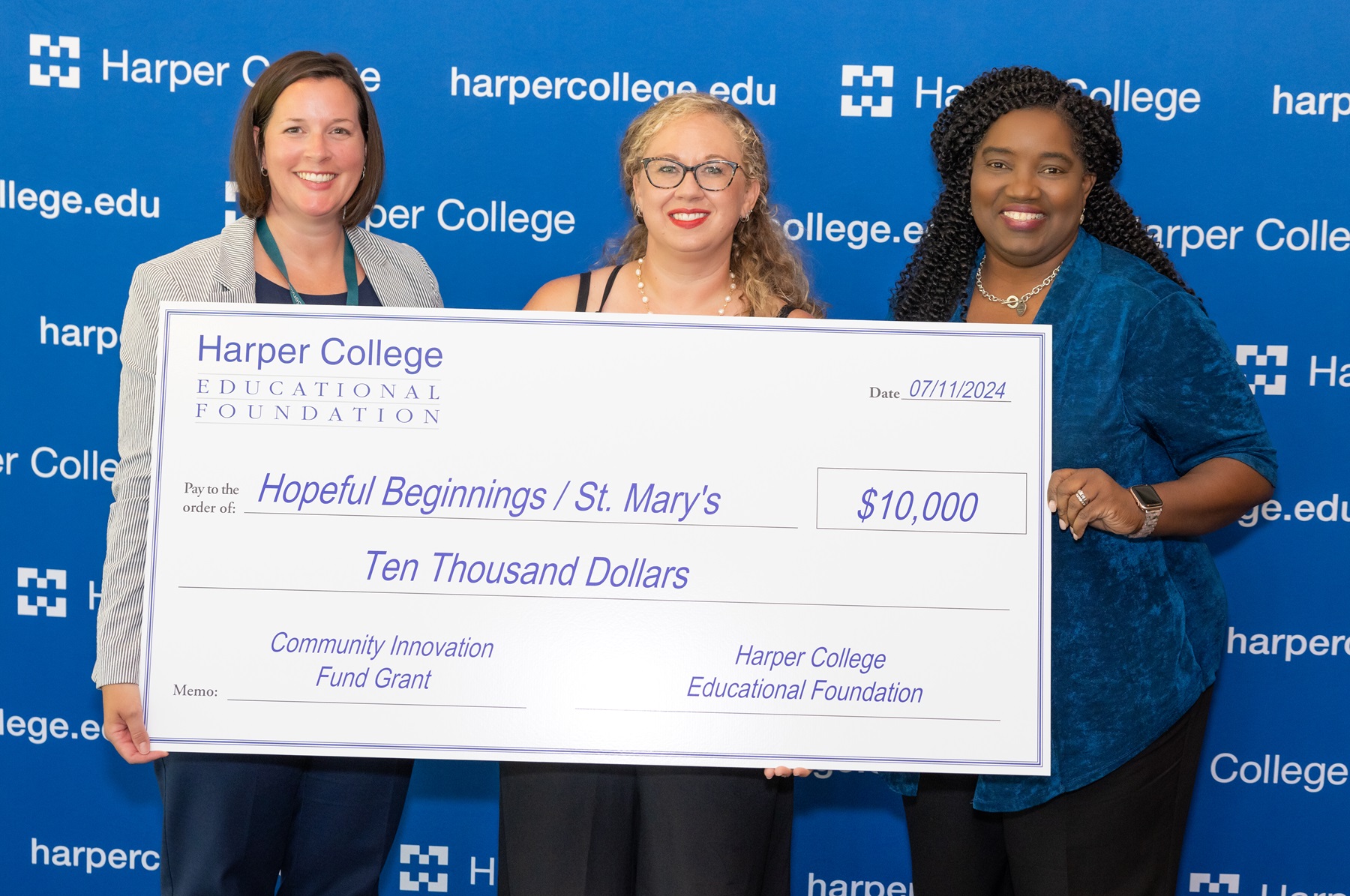 Heather Zoldak, Natalie Rodriguez and Dr. Avis Proctor stand with a commemorative check from the Harper College Educational Foundation.