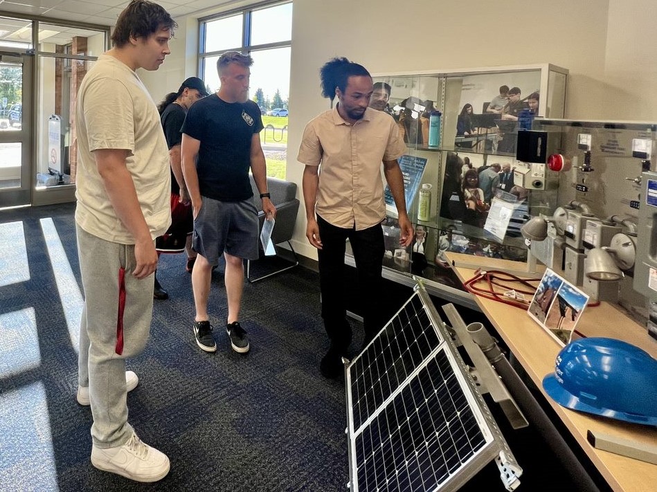 Instructor Corey Wirrick, right, demonstrates a solar demo unit with Continuing Professional Education students.