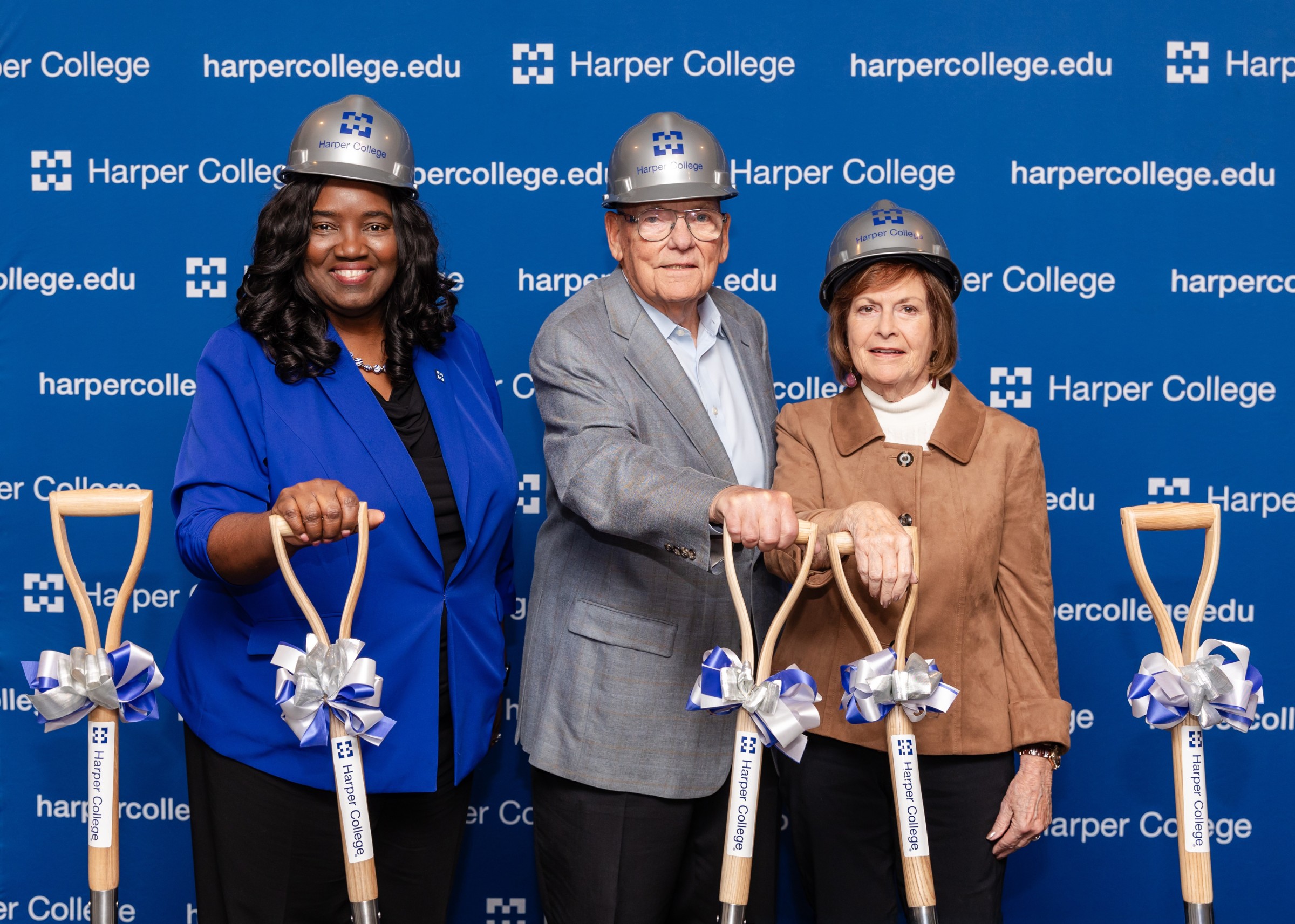 Dr. Avis Proctor, John Canning and Rita Canning stand with shovels and hardhats.