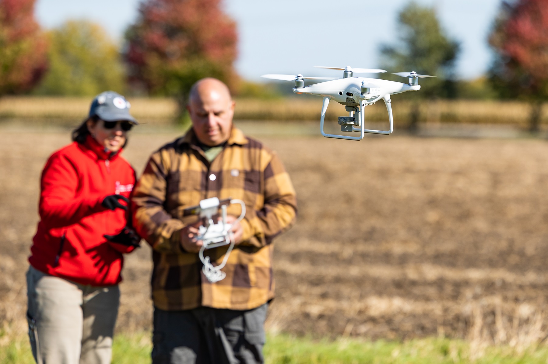 An instructor and students work on flying a drone