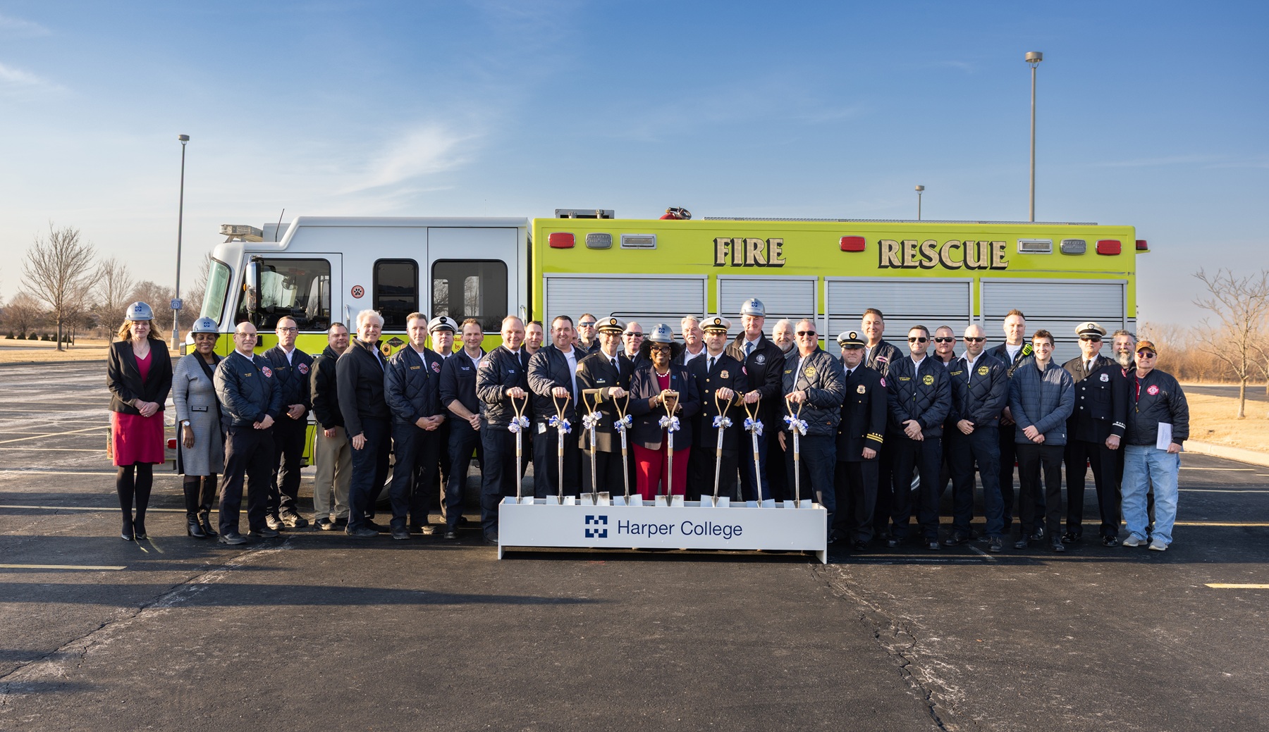 Dr. Avis Proctor, Harper College president, stands with dozens of area fire chiefs, firefighters and first responders to celebrate the groundbreaking of Harper's new Emergency Services Training Center.