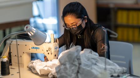 Harper College student Karla Bautista sews a garment for the upcoming fashion show