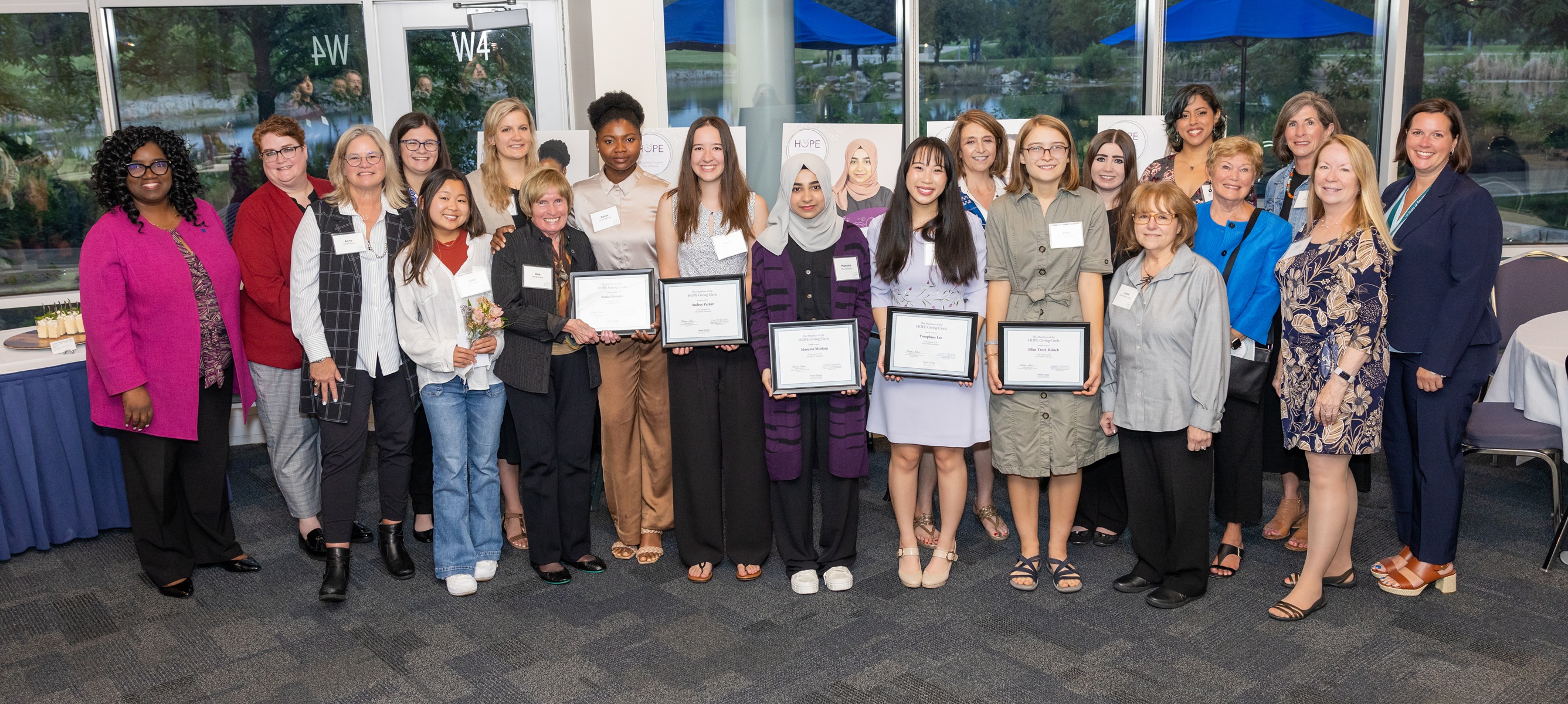 Past and present HOPE Scholarship recipients stand with HOPE Giving Circle Members