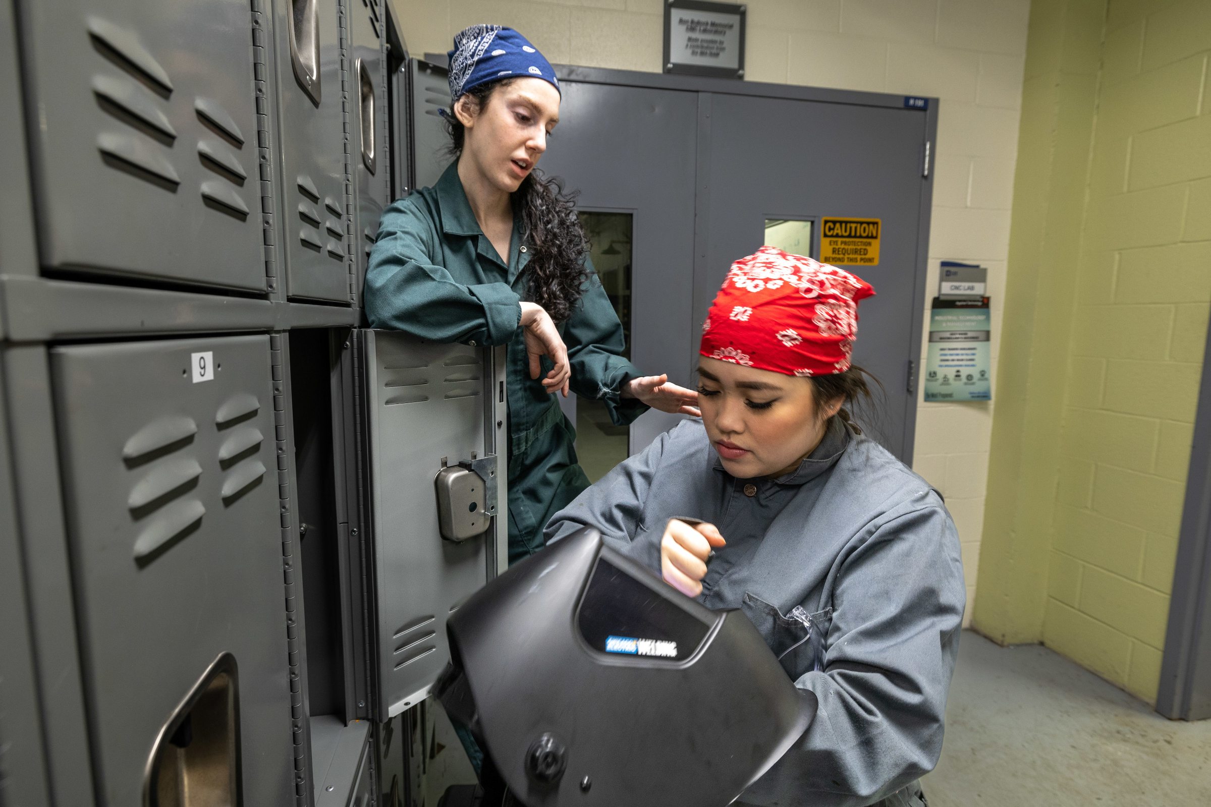 Characters in Lettie talk near a locker