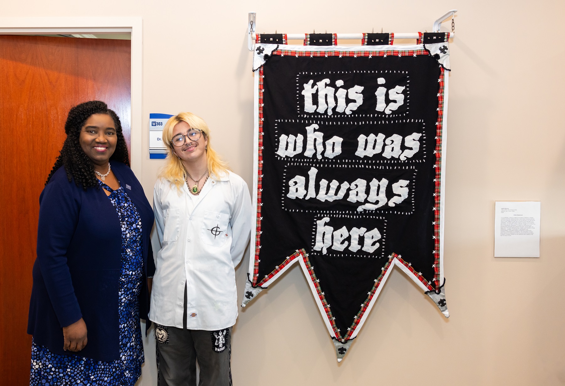 Dr. Avis Proctor and Lain Dennis stand with Lain's artwork.