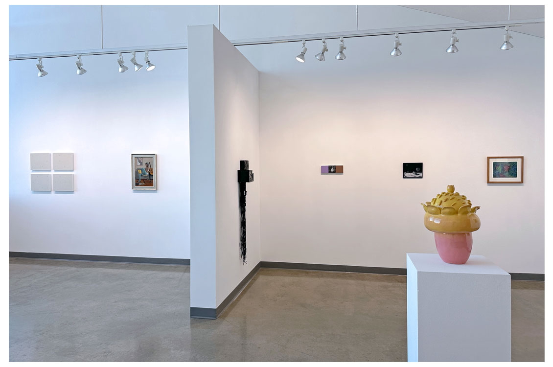 interior gallery view with paintings on walls and sculpture in foreground