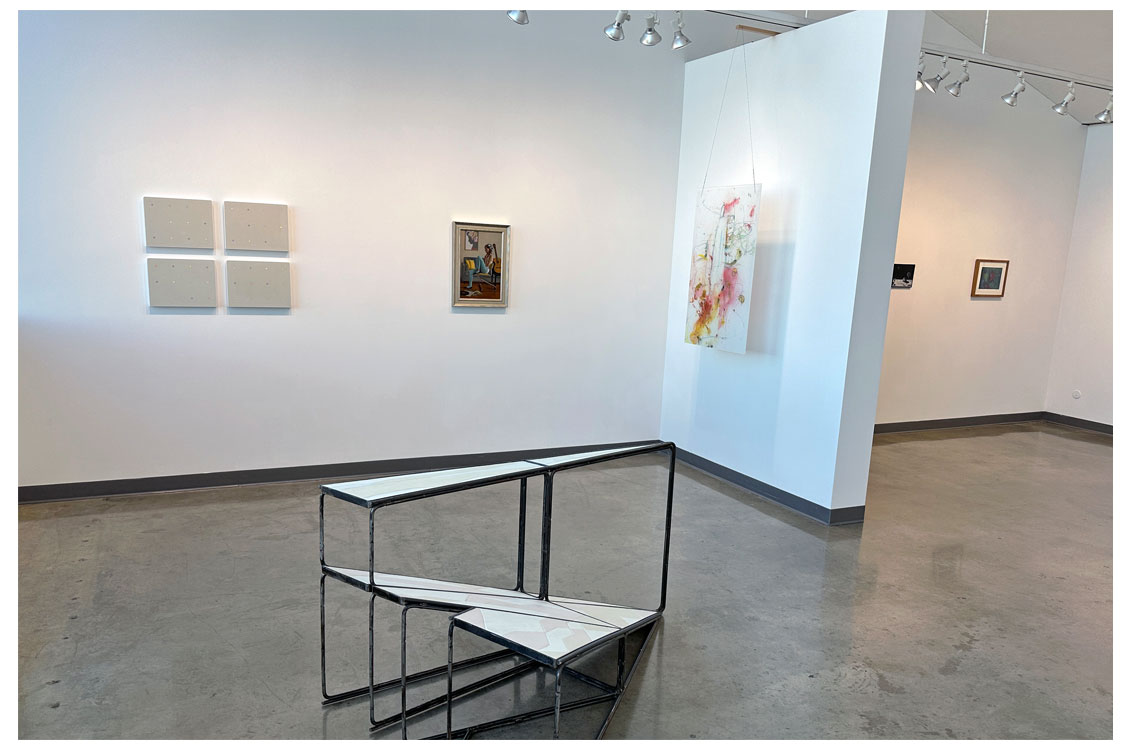 interior gallery view with large sculpture displayed in foreground