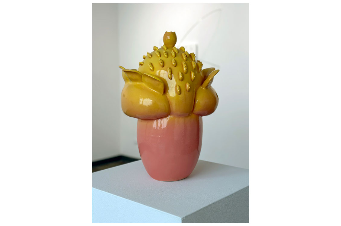 a floral abstract sculpture with coral glaze on bottom transitioning to yellow glaze on top