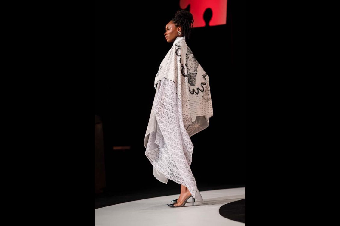 Woman wearing a long white patterend draped shawl