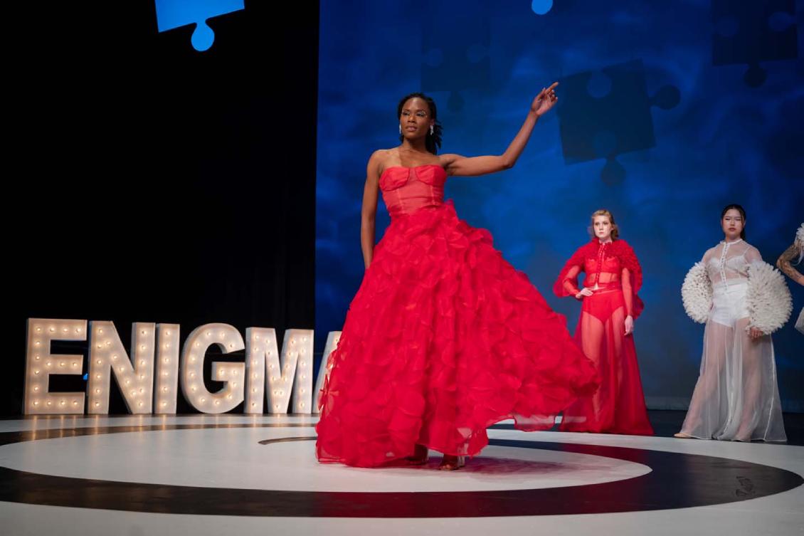 Model posing in a sleeveless, red, ruffled gown"