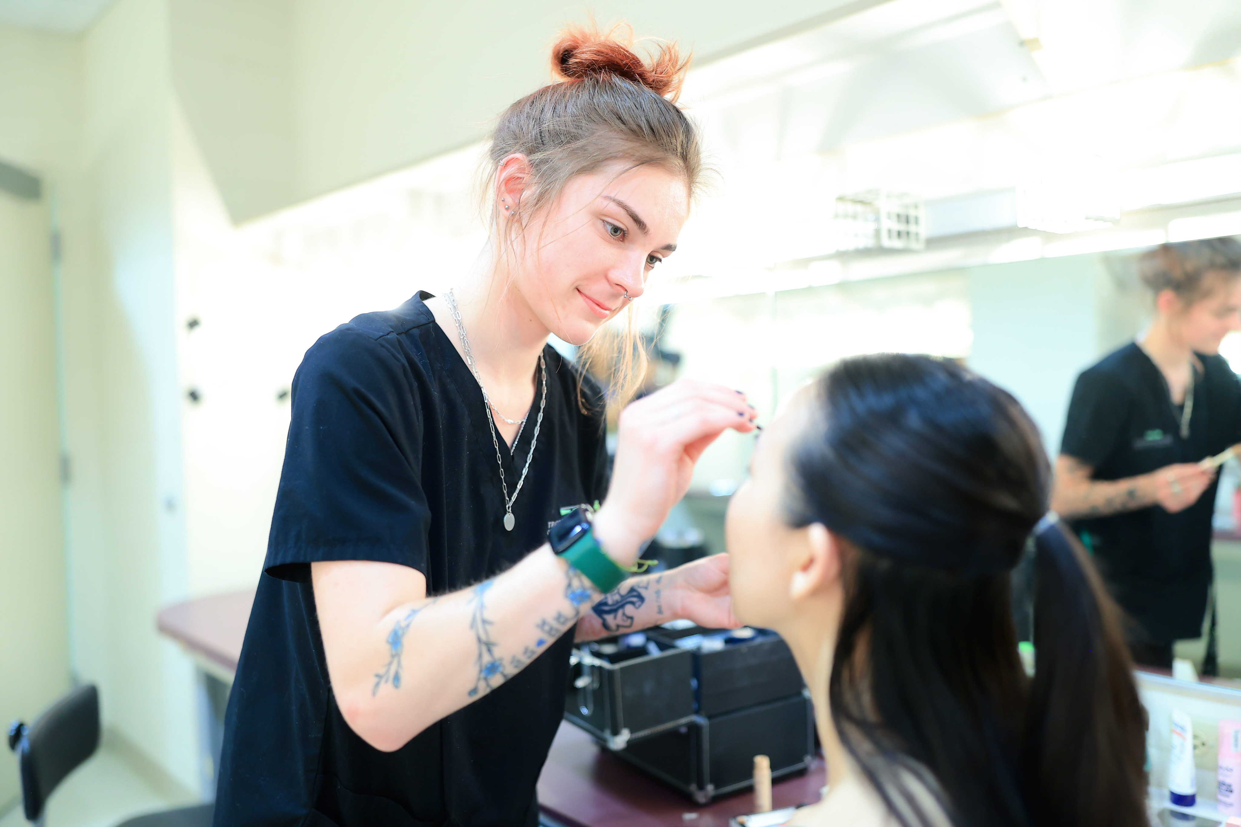 A makeup artist putting makeup one one of the models back stage