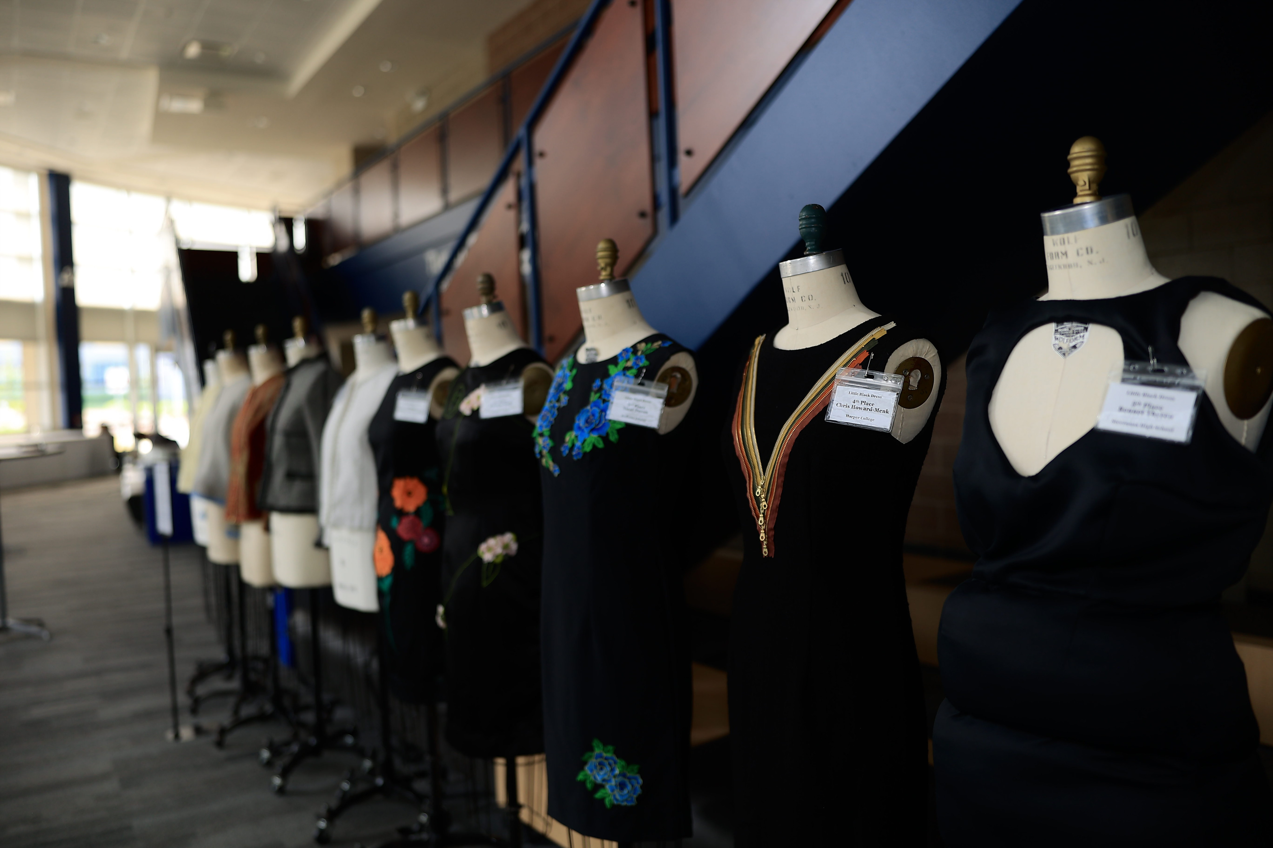 A line of mannequins dress in different outfits created by students