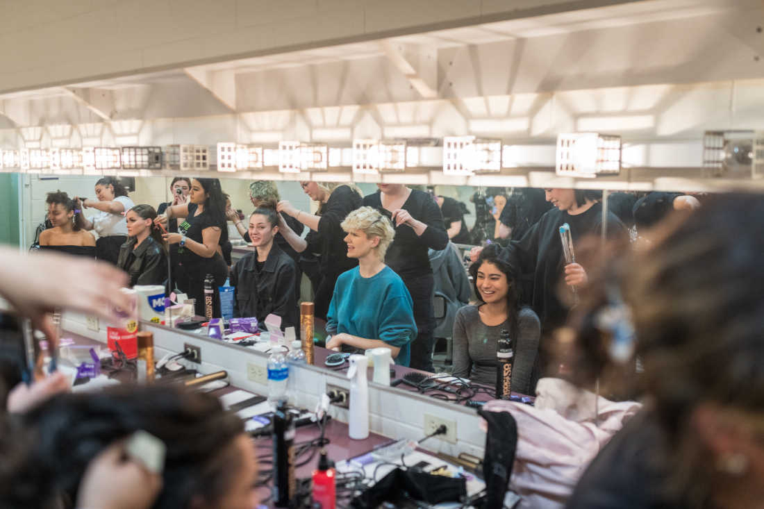 Models in the dressing room getting hair and makeup done