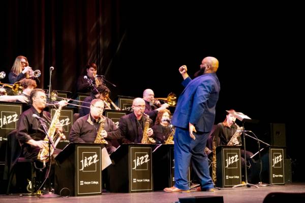 A close view of the conductor passionately directing the jazz band onstage.