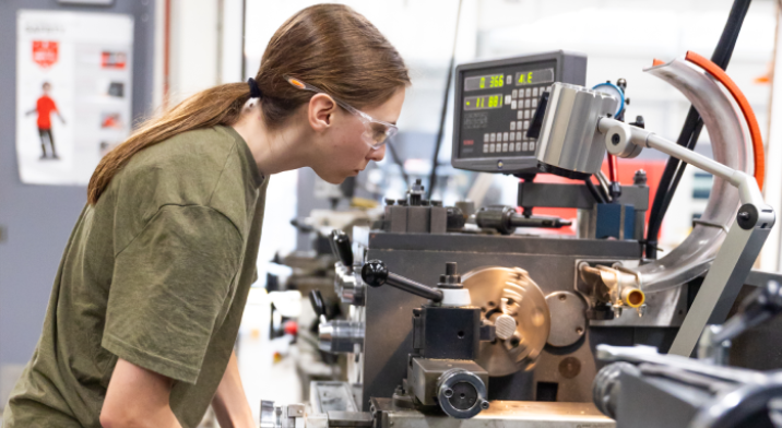 A student works on a with a piece of equipment in the Harper Manufacturing Lab.