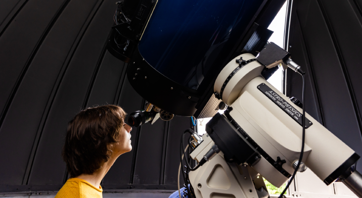 A student looks at the sky using the telescope in the Harper College Heinze Observatory.