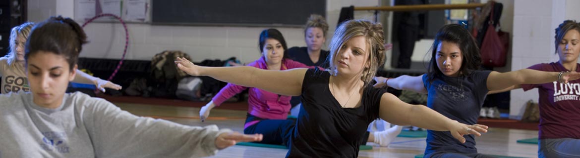Group of women in the kinesiology program doing yoga and stretching, training to become a sports kinesiologist