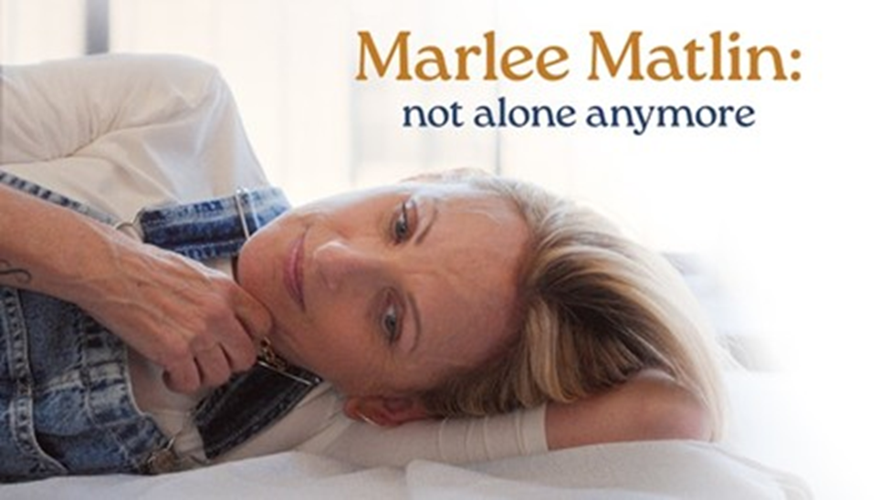 Photograph showing Marlee Matlin in left lateral recumbent position with delicate lines showing in forward hand-advertising Marlee Matlin--not alone anymore documentary film