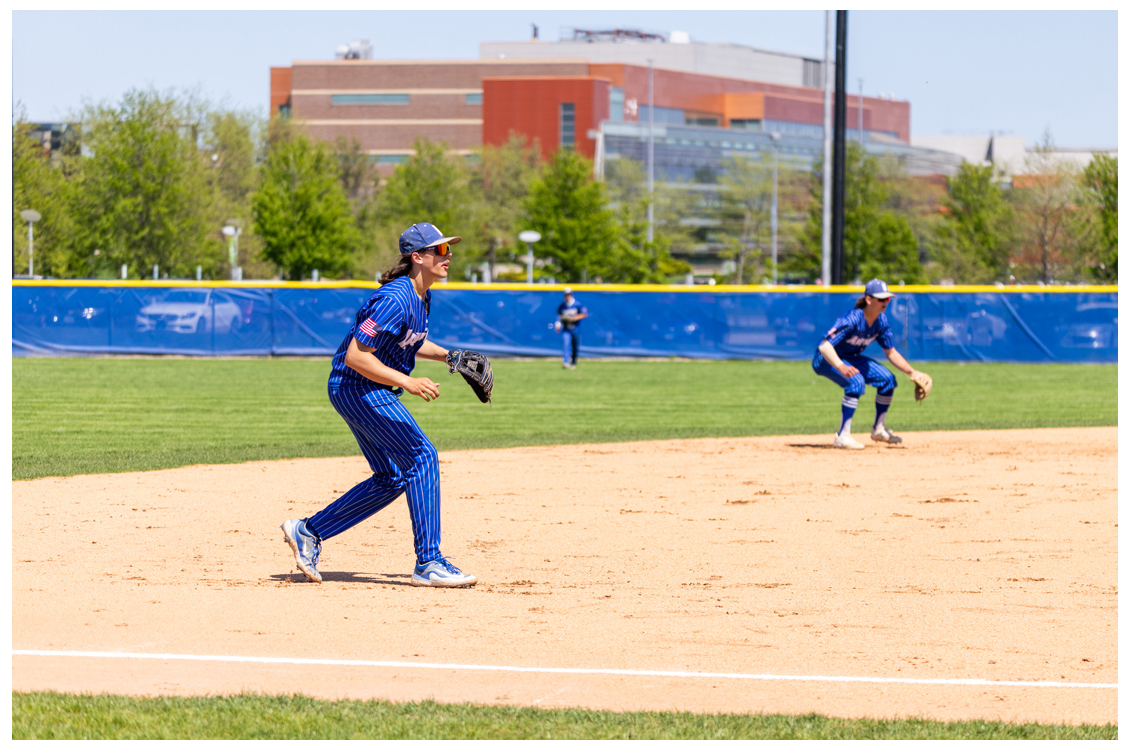 Two students playing baseball on a field