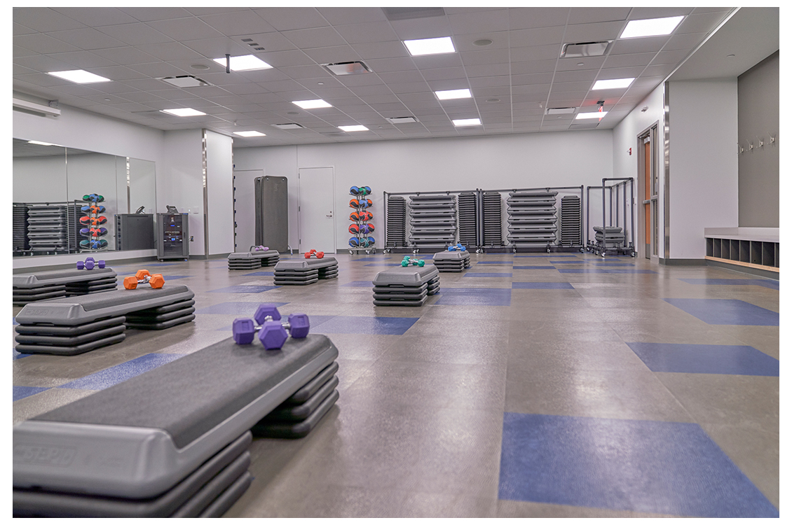 a gym room with steps and weights set up