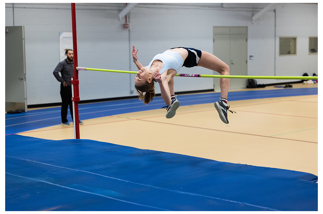 student leaping over pole vault