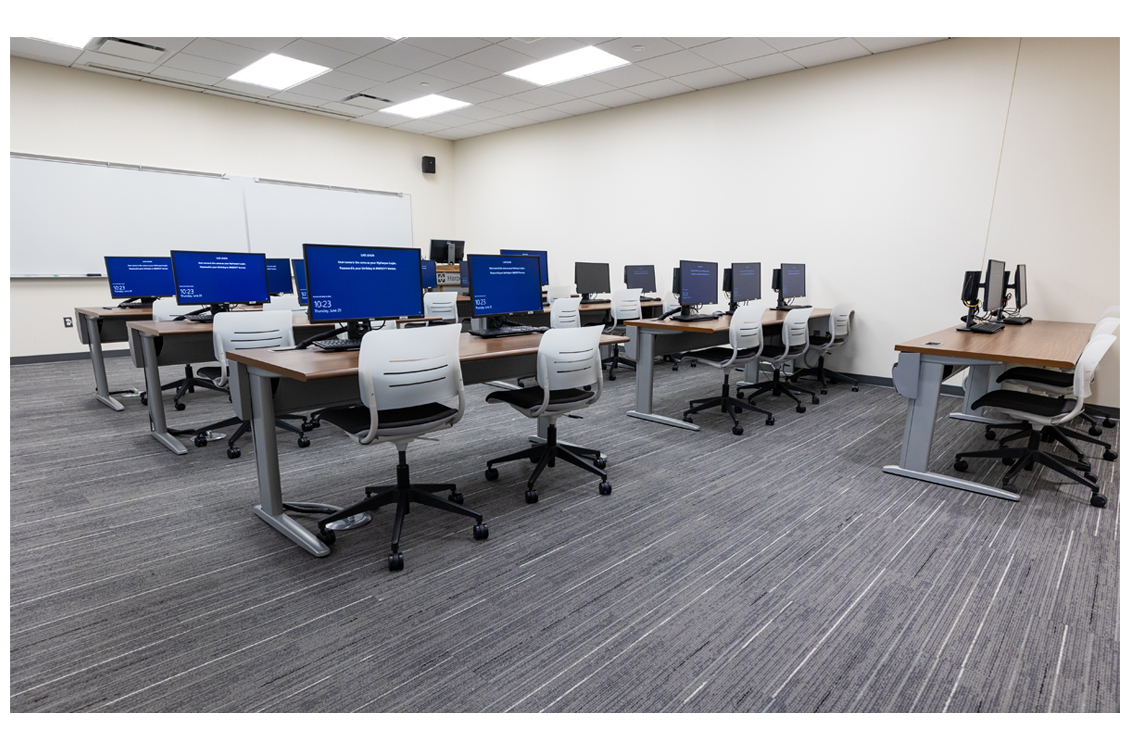 an empty classroom with rows of computers