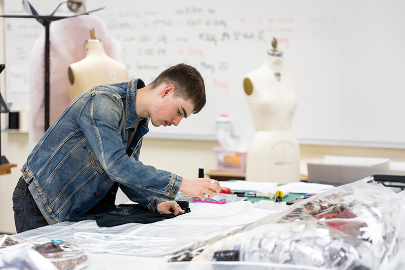 Student working on a fashion design project in an art studio