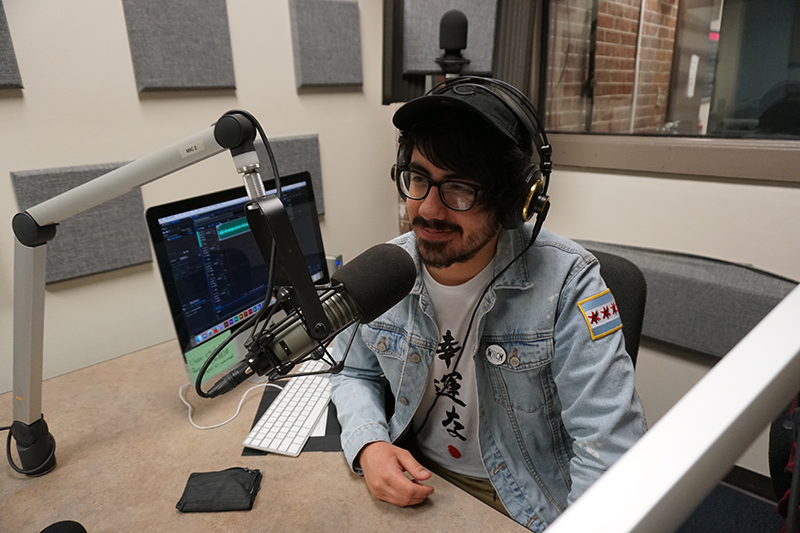 Radio host speaking into a microphone in a studio