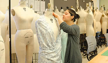 fashion designer pinning up a dress design