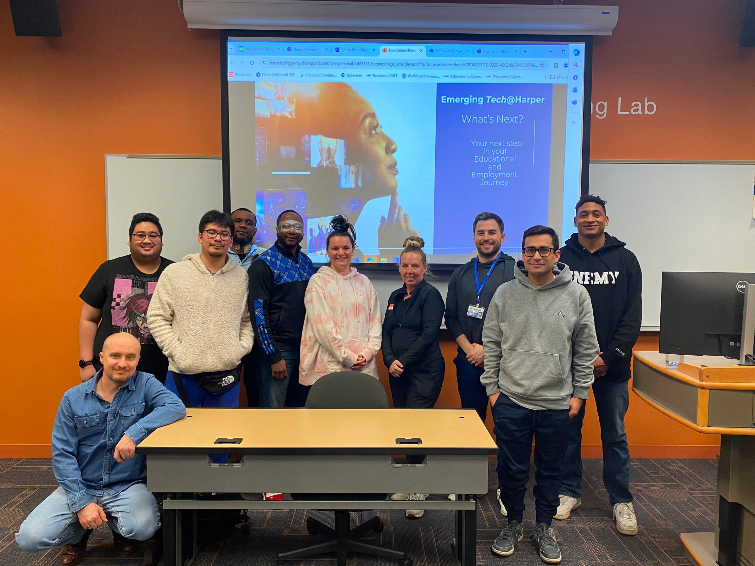A group of BILT collaborators standing in front of a projection screen
