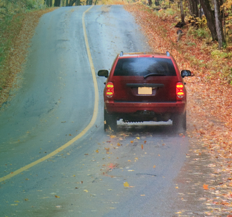 Car driving on a road in fall