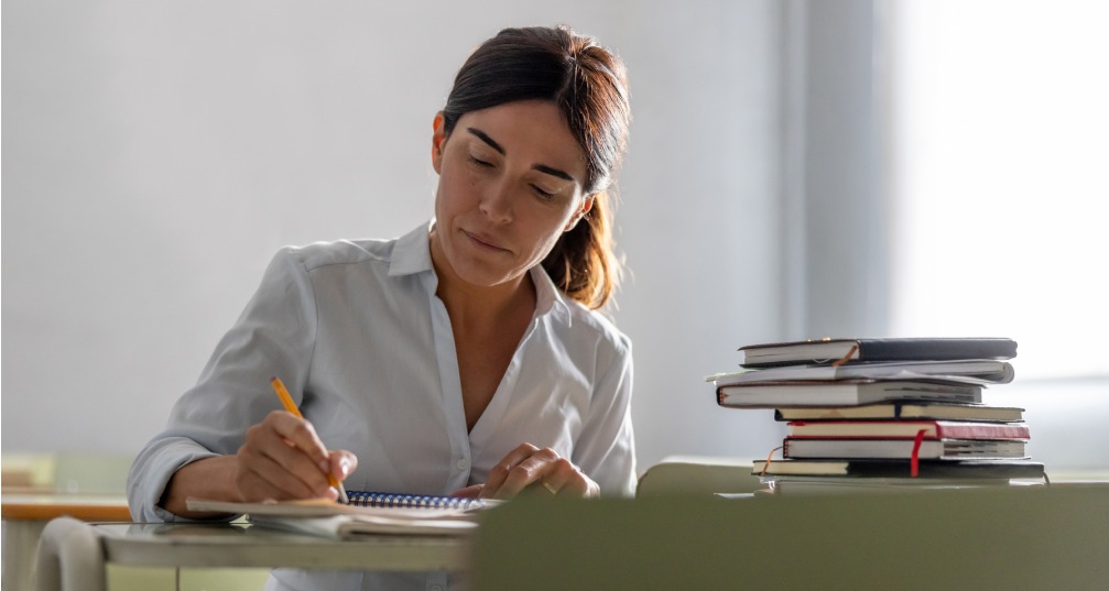 a woman sitting at a desk and writes an essay