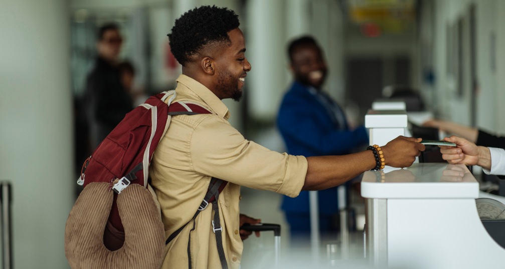 a man takes his ticket from across the counter at an airport