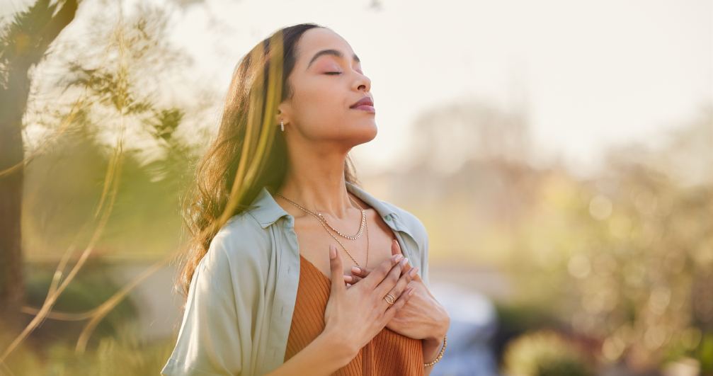 woman outside, breathing in the fresh air and practicing gratitude