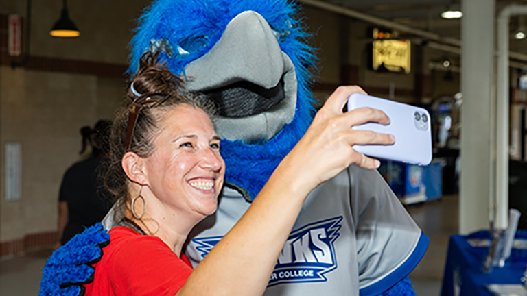 Student posing with Harper Hawk