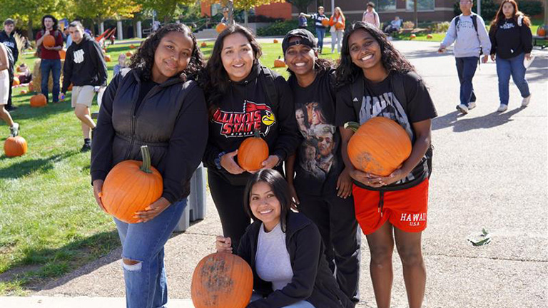 students posing with pumpkins