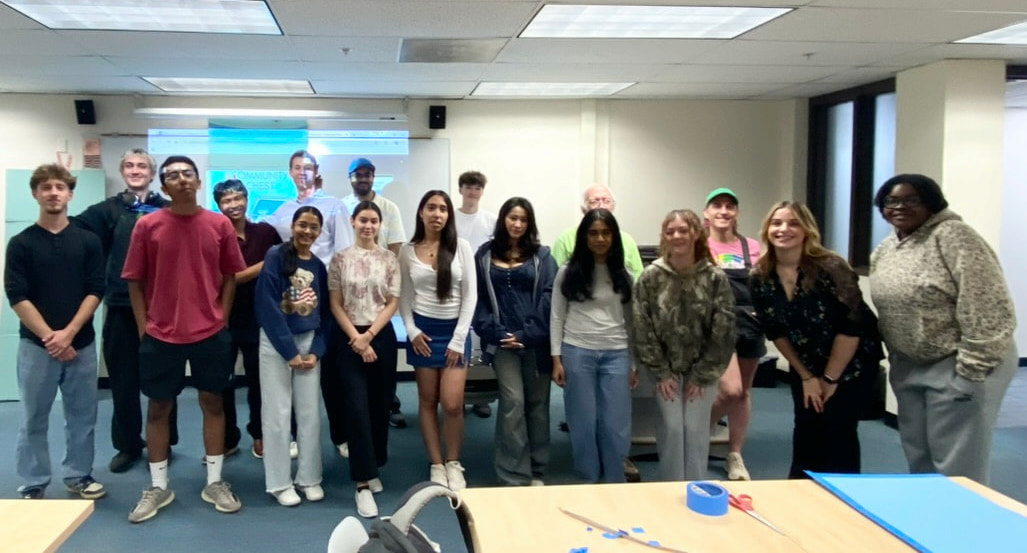 Harper College Business Club members standing together in a classroom, posing for a group photo at the end of a meeting