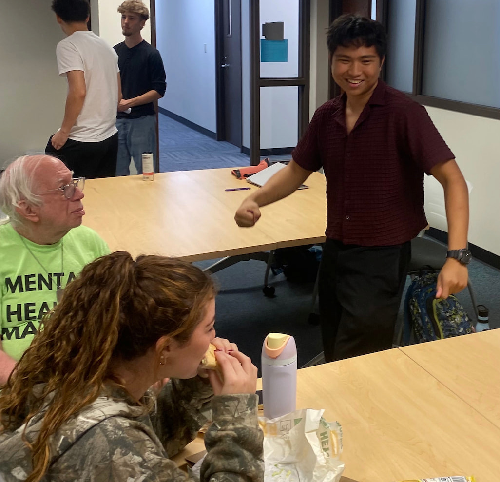 Harper College Business Club members gathered around a table and socializing while eating